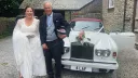 Couple standing in front of a classic White rolls-Royce at a Devon venue
