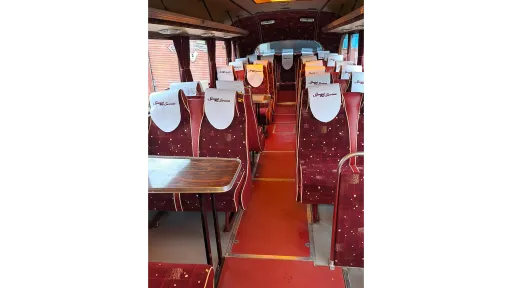 Interior of a vintage single-decker bus showing red patterned seats.