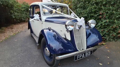 Blue and ivory 1937 Austin 10 Cambridge parked on a quiet road, highlighting the classic chrome grille and vintage charm suitable for Leicester weddings.