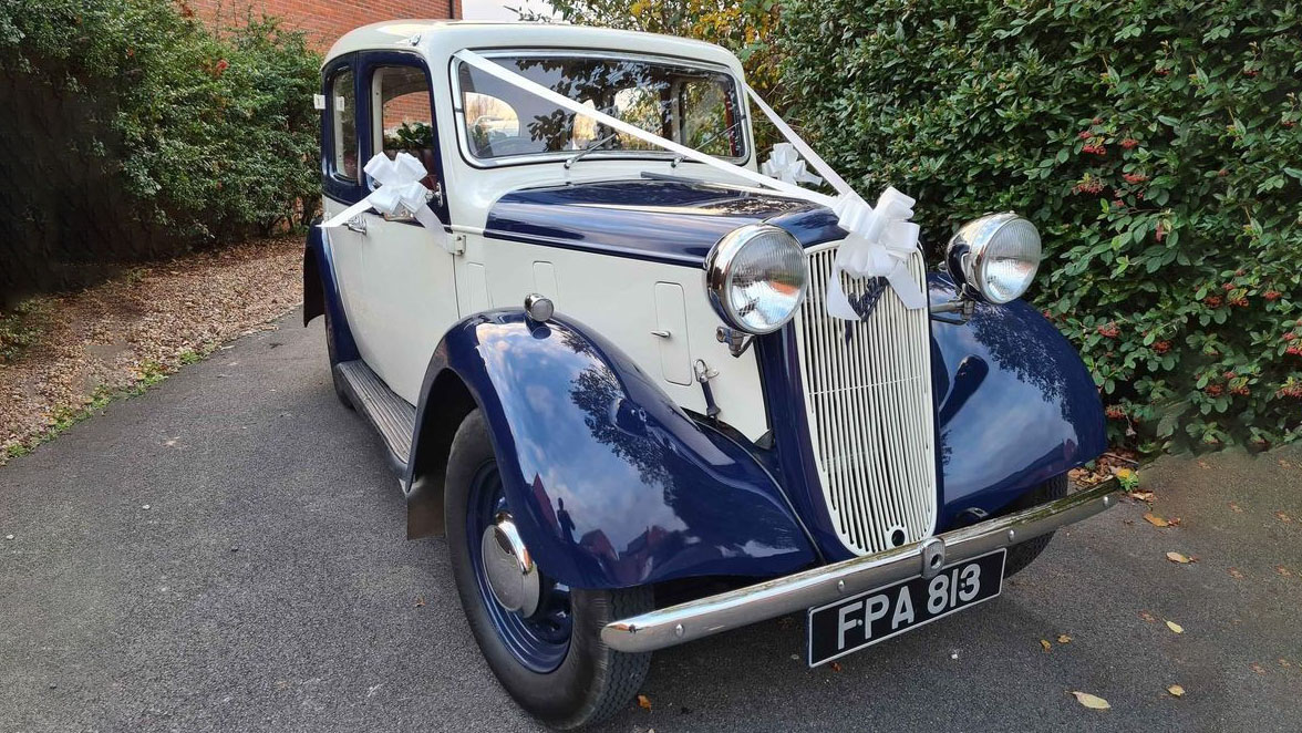 Blue and ivory 1937 Austin 10 Cambridge parked on a quiet road, highlighting the classic chrome grille and vintage charm suitable for Leicester weddings.