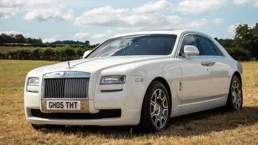 Front view of a White Rolls-Royce Ghost with alloy wheels and chrome front grill