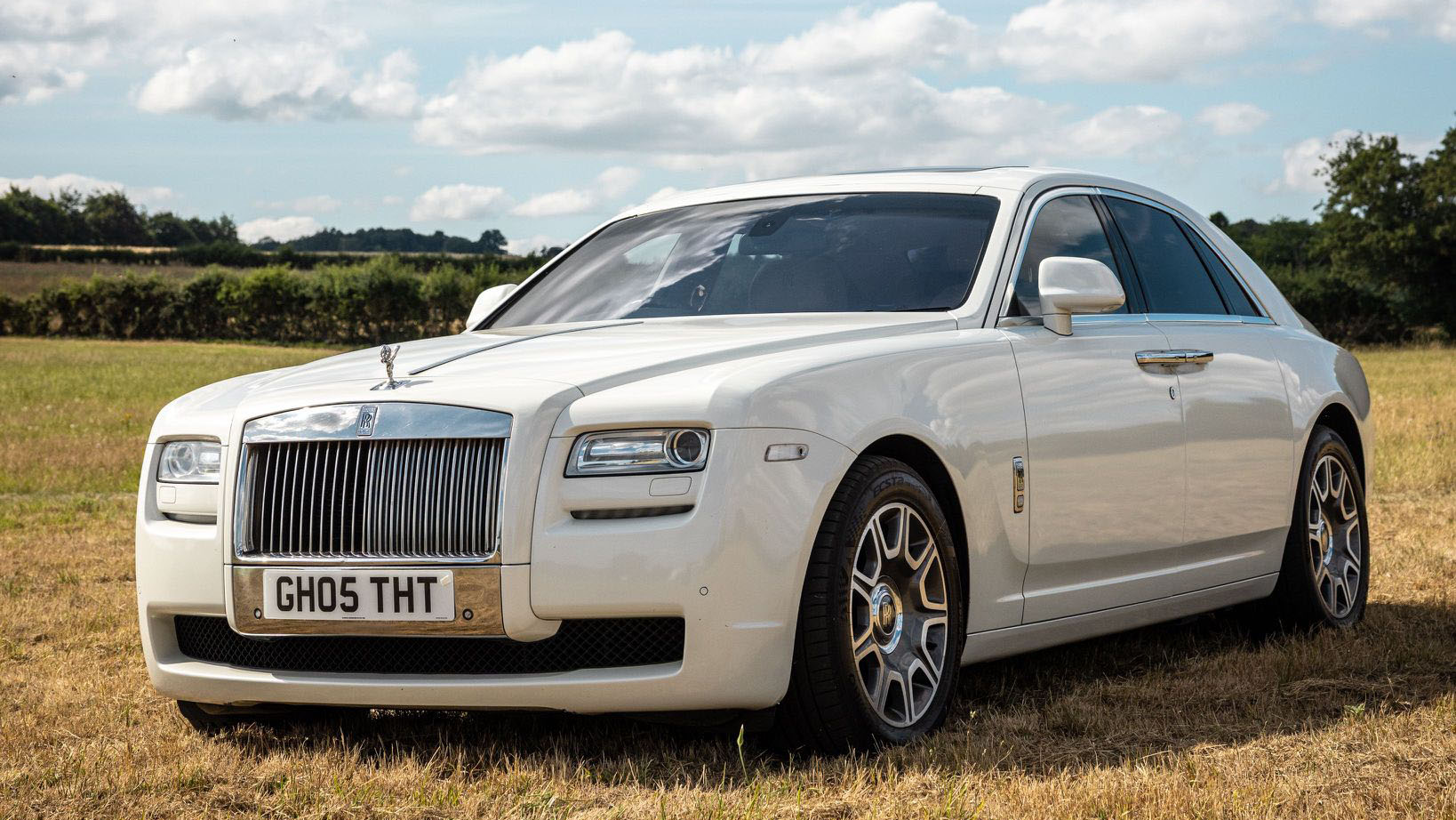 Front view of a White Rolls-Royce Ghost with alloy wheels and chrome front grill