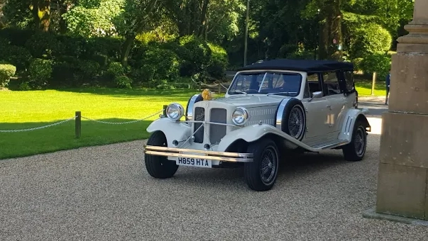 Beauford 4-door convertible wedding car in Old English White parked on a tree-lined driveway at a Yorkshire wedding venue