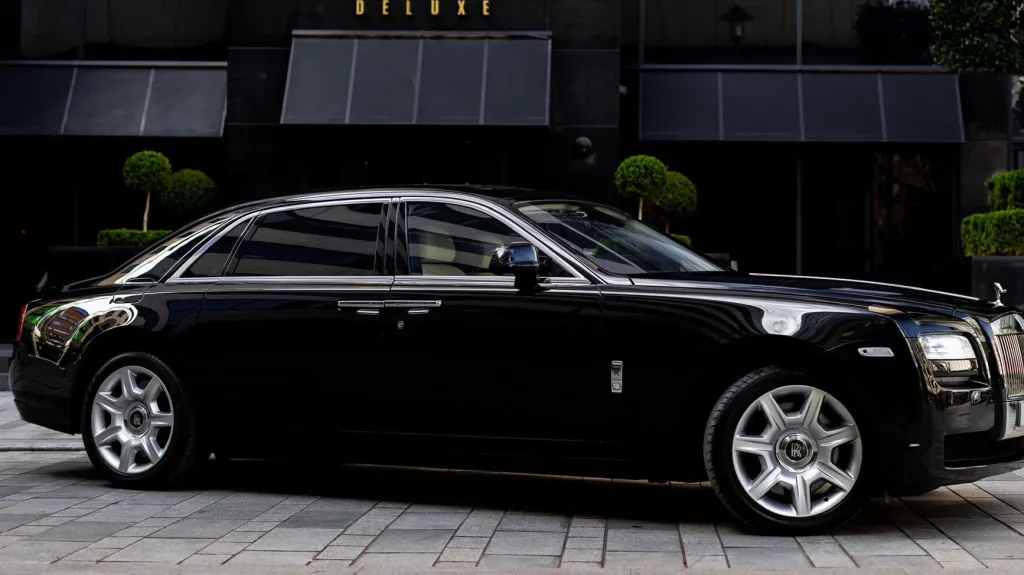 Black Rolls-Royce Ghost wedding car parked outside a modern building in Yorkshire, showing its sleek luxury saloon profile