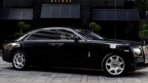 Black Rolls-Royce Ghost wedding car parked outside a modern building in Yorkshire, showing its sleek luxury saloon profile