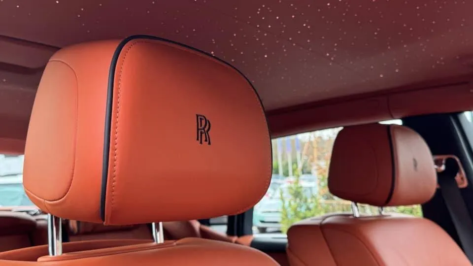 Brown leather headrest with Rolls-Royce RR emblem inside Phantom VIII