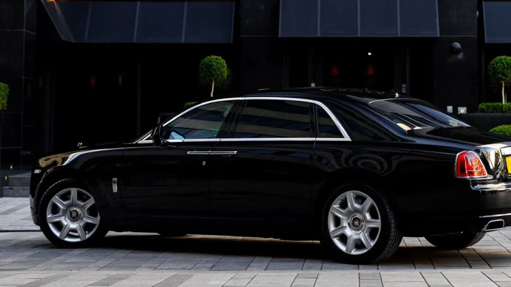 Left side view of a black Rolls-Royce Ghost wedding car photographed in Bradford, highlighting its long wheelbase and refined styling