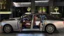 Side view of black and silver Rolls-Royce Phantom VIII with rear coach doors open