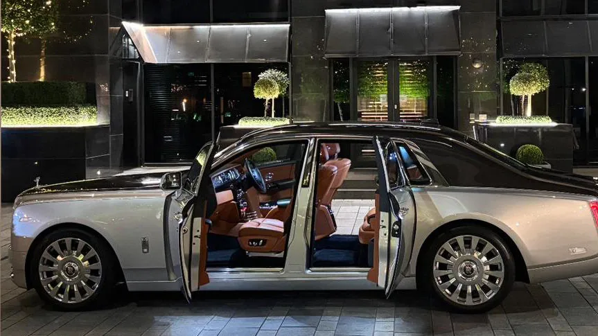 Side view of black and silver Rolls-Royce Phantom VIII with rear coach doors open