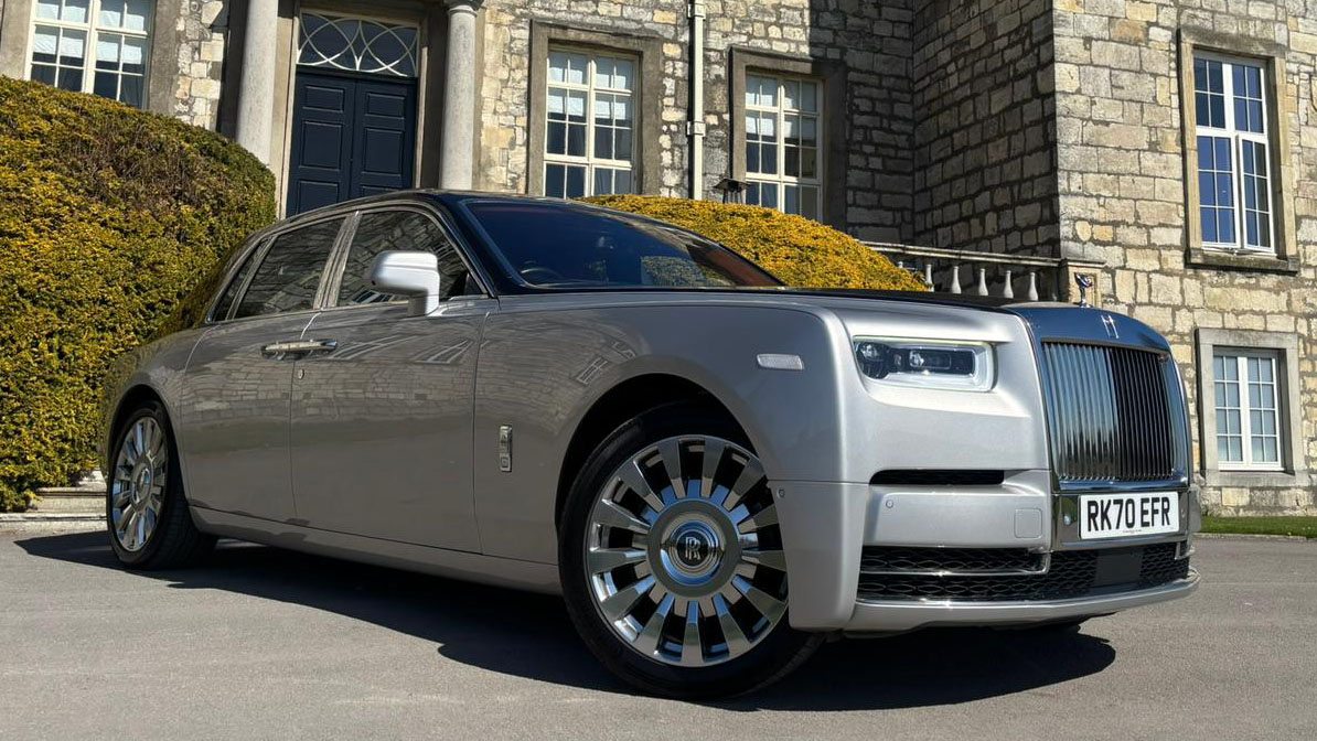 Black and silver Rolls-Royce Phantom VIII luxury wedding car parked outside venue