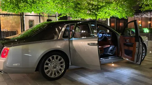 Rear three-quarter view of black and silver Rolls-Royce Phantom VIII with doors open