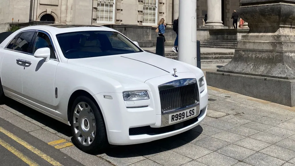 White Rolls-Royce Ghost wedding car parked in Bradford, photographed from a front three-quarter angle outside a grand building