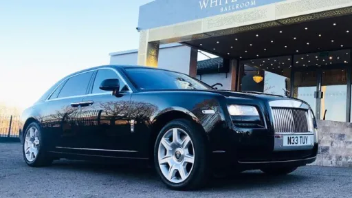 Modern black Rolls-Royce Ghost wedding car photographed from a front three-quarter angle at a Yorkshire wedding venue