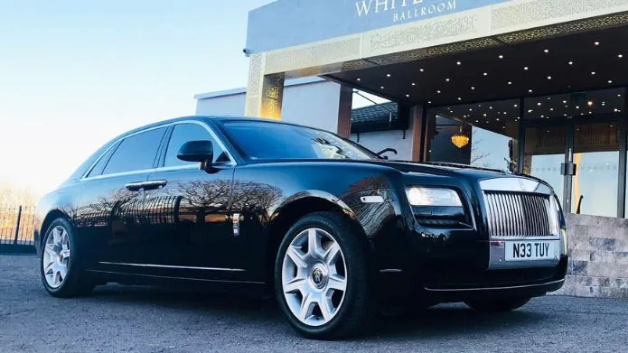 Modern black Rolls-Royce Ghost wedding car photographed from a front three-quarter angle at a Yorkshire wedding venue