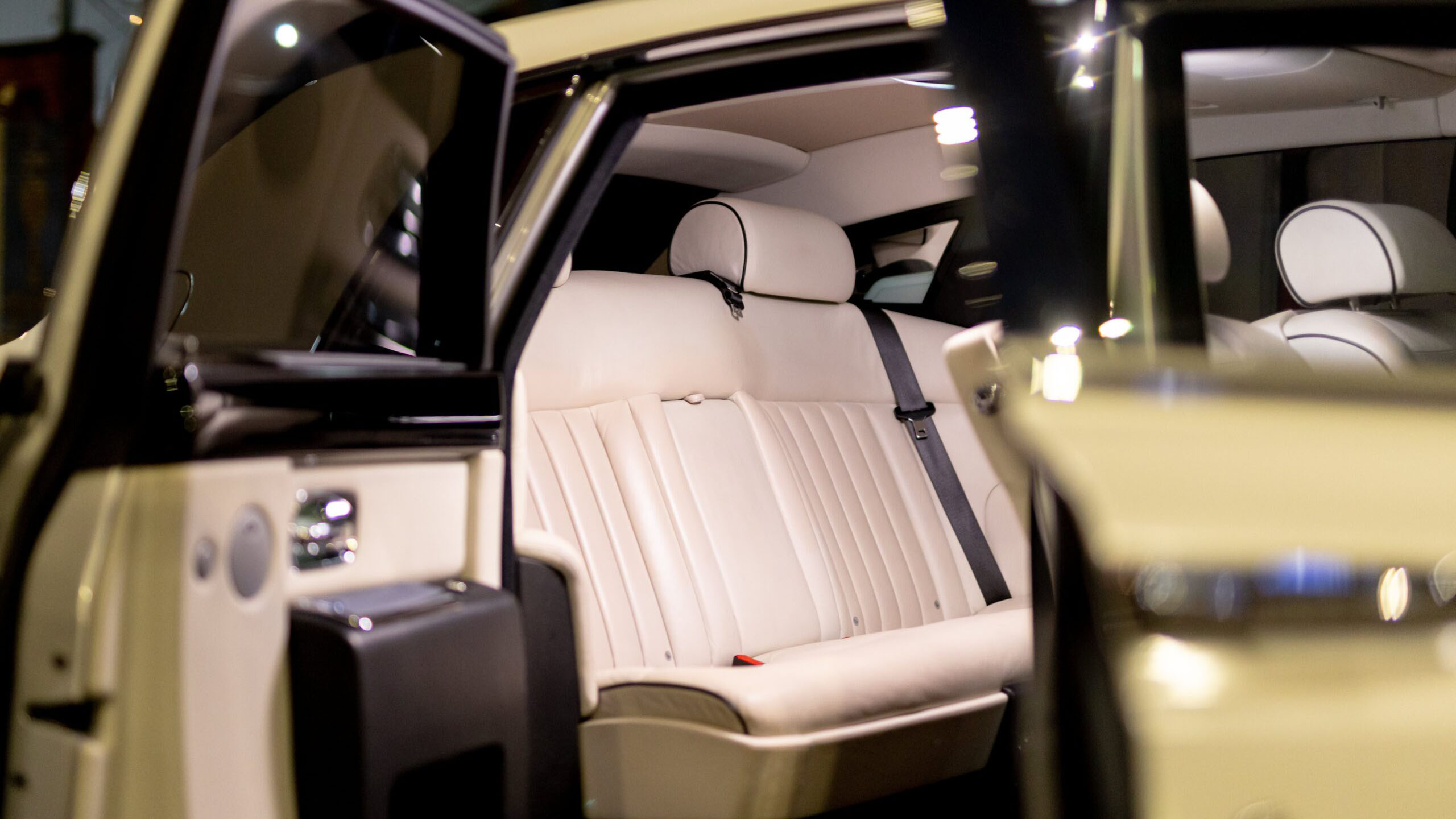Cream leather interior of a Rolls-Royce Phantom wedding car showing rear passenger seating and luxury cabin details