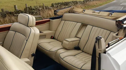 Cream leather interior of a Rolls-Royce Corniche wedding car showing rear seating and classic luxury cabin details