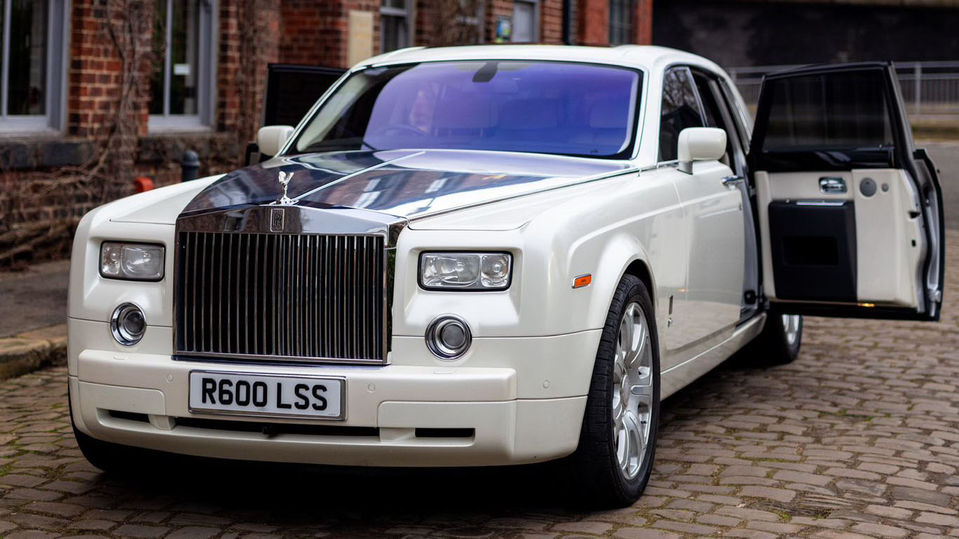 Front left view of a white Rolls-Royce Phantom wedding car with rear passenger door open, showing easy access for bridal entry
