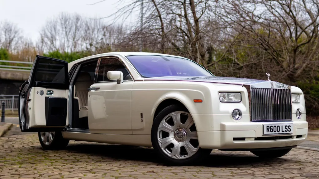 Front right view of a white Rolls-Royce Phantom wedding car with rear passenger door open, ideal for bride arrival photographs