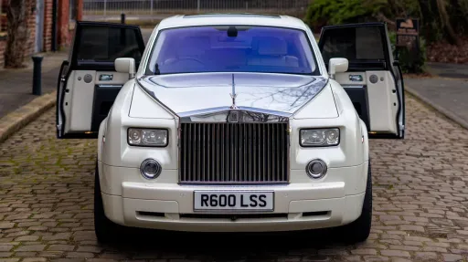 Front view of a white Rolls-Royce Phantom wedding car with rear doors open, photographed at a wedding venue in West Yorkshire