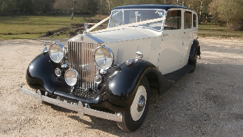 Left side view vintage rolls-royce in Black and Ivory decorated with ivory wedding ribbons