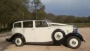 Right side view vintage Rolls-Royce Silver Wraith in Ivory with black wheel arches and spare wheel mounted on the side of the vehicle