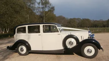 Right side view vintage Rolls-Royce Silver Wraith in Ivory with black wheel arches and spare wheel mounted on the side of the vehicle