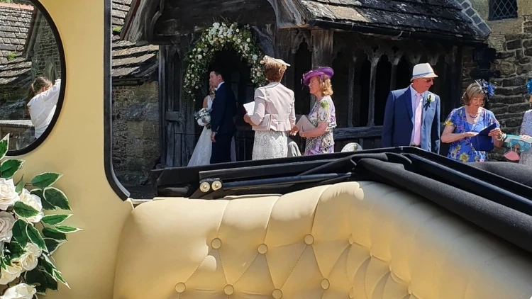Rear convertible section of a cream 1930s style Imperial wedding car with open roof for wedding photographs.