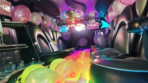 Hummer limousine interior with black leather seating, colour changing LED lights and balloon decorations.
