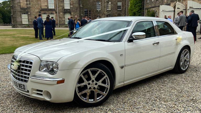 White Chrysler 300C wedding car with chrome alloys arriving at Yorkshire wedding venue