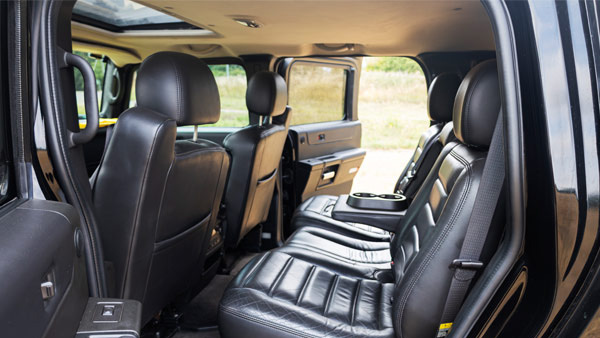 Black leather interior of Hummer H2 showing rear seating area with dark upholstery and spacious cabin layout.