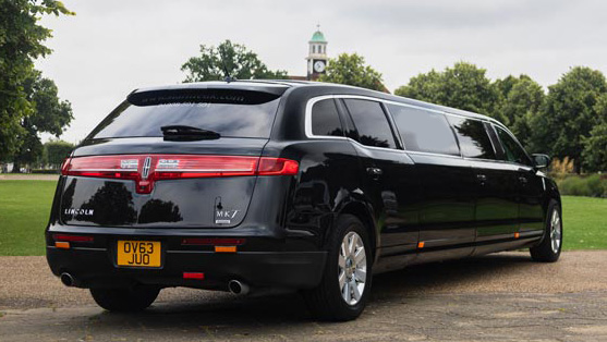 Rear three quarter view of black Lincoln MKT limousine with wraparound tail lights and extended stretch body.