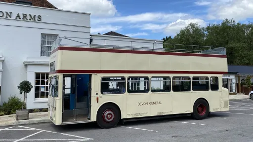 Cream Leyland double decker wedding bus parked outside a traditional country pub wedding venue.