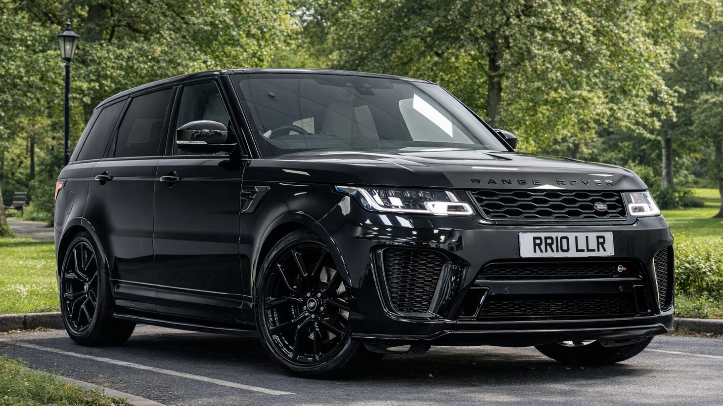 Black ange Rover Sport SVR parked in a park with greenery all around