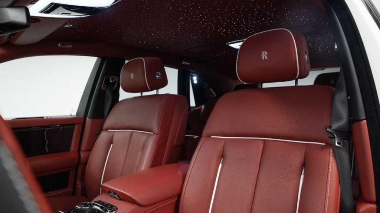Interior view of Rolls-Royce Phantom 8 showing red leather seating, luxury dashboard trim and premium handcrafted interior finish.
