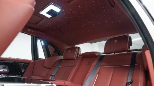 Rolls-Royce Phantom VIII interior showing the illuminated starlight headliner above red leather rear seats and luxury cabin trim.