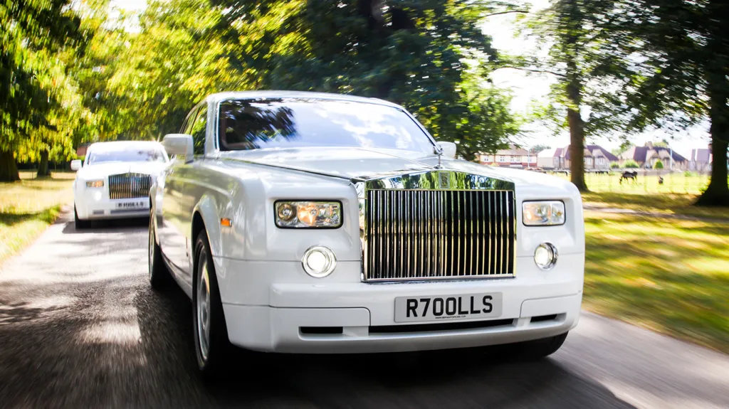 Front view of a white Rolls-Royce Phantom wedding car showing the iconic polished chrome grille, Spirit of Ecstasy bonnet ornament and luxury styling.