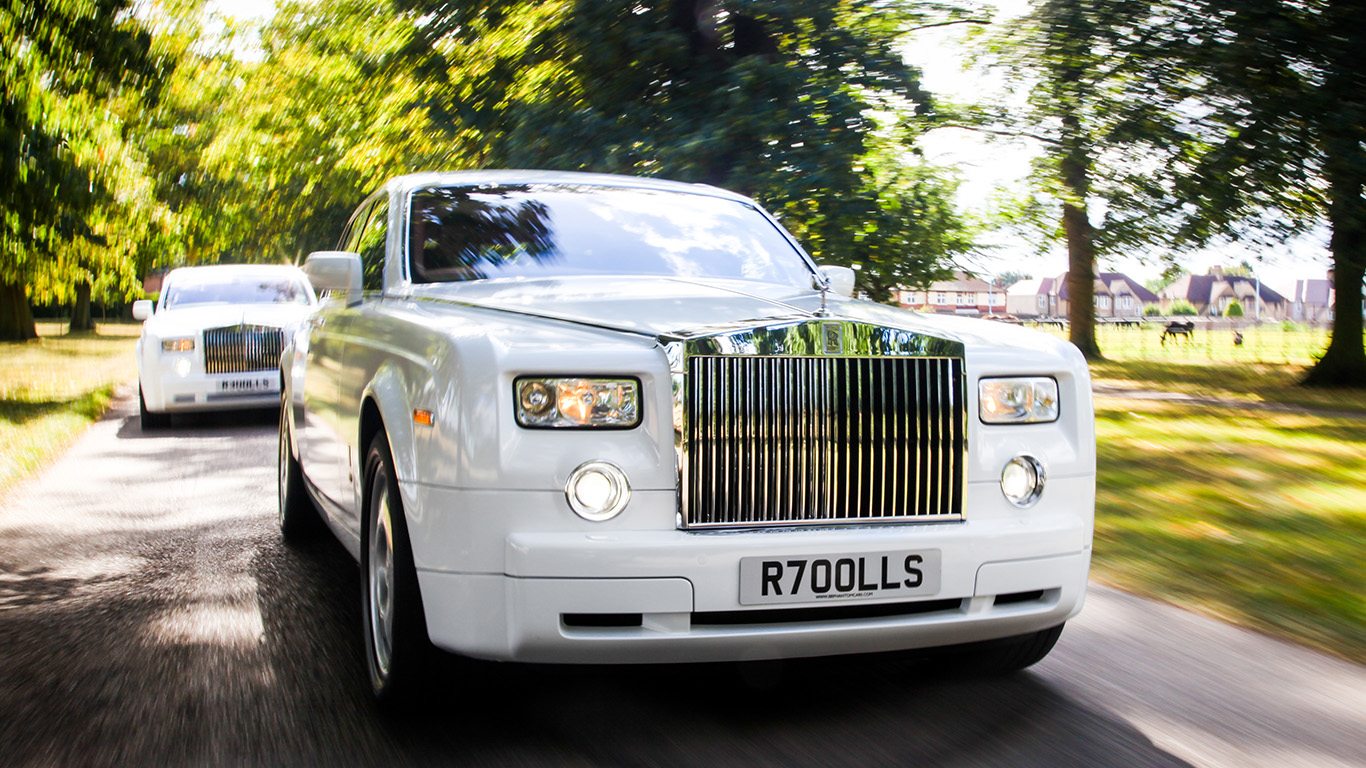 Front view of a white Rolls-Royce Phantom wedding car showing the iconic polished chrome grille, Spirit of Ecstasy bonnet ornament and luxury styling.