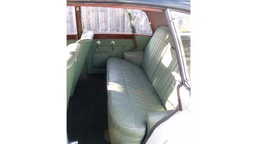 Rear interior bench seat of Armstrong Siddeley in light leather, spacious cabin with classic trim details