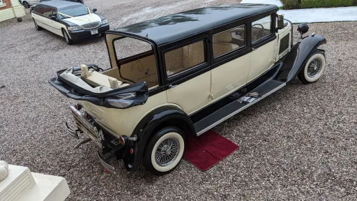 Elevated rear view of black and ivory Bramwith limousine parked on gravel, showing full length and cream interior layout.