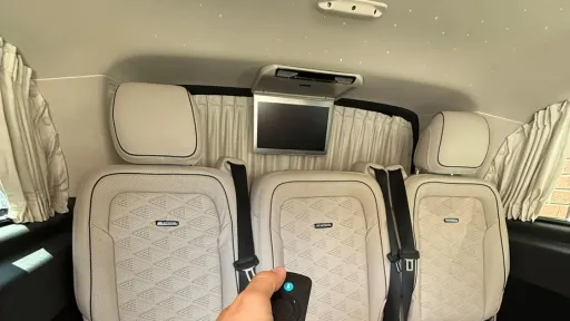 Cream leather interior of Mercedes V-Class with three individual rear seats, spacious cabin and soft lighting.