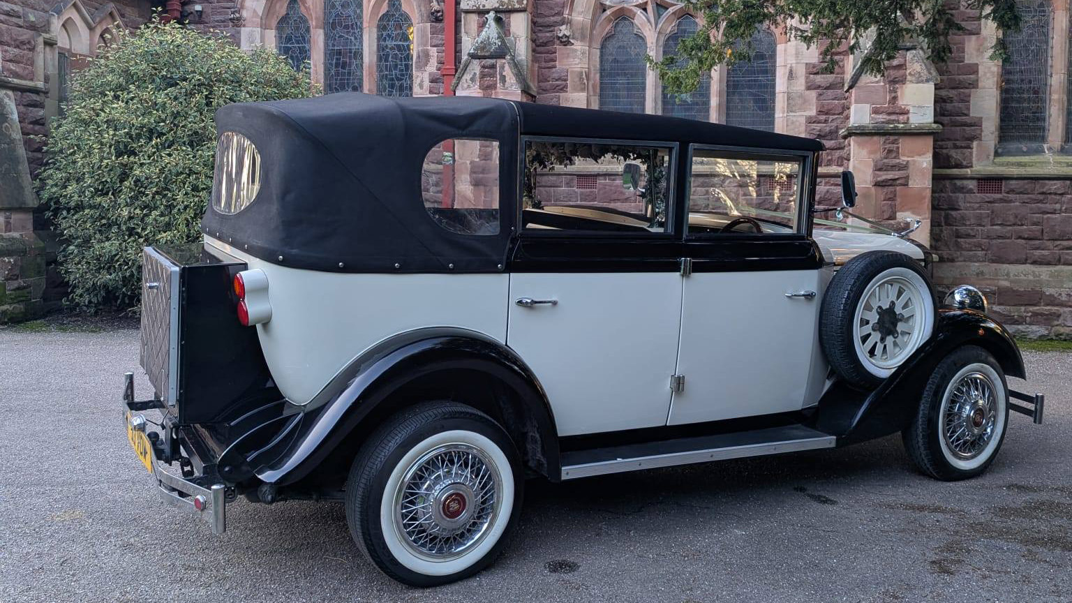 Rear right view of Cowley landaulette limousine with roof closed, showing picnic trunk, spare wheel and chrome bumper.