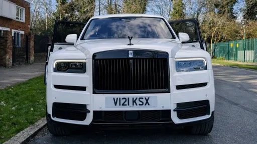 Full view of White rolls-royce Cullinan with large Black and Silver alloy wheels and chrome front grill
