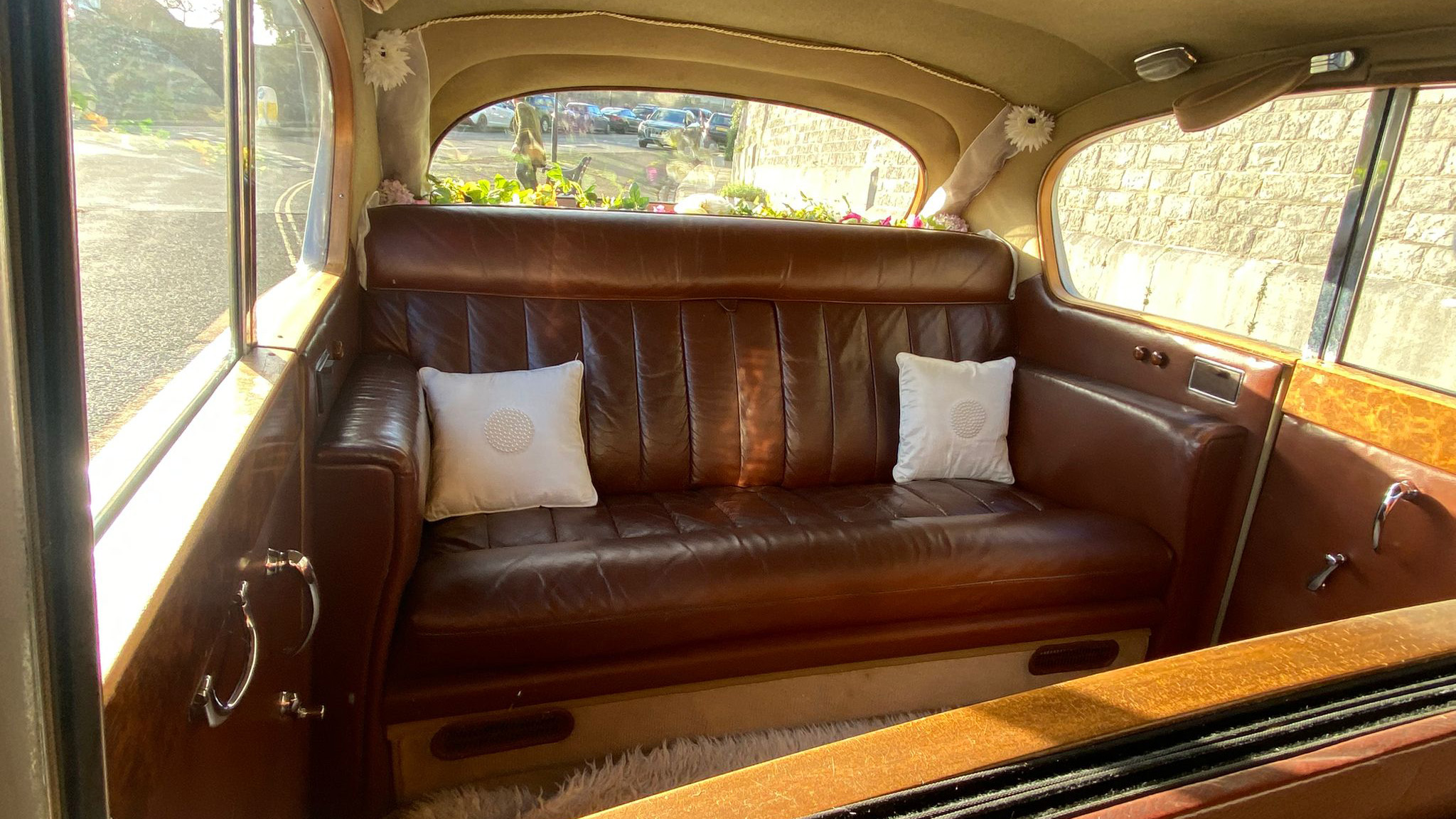Rear cabin of Austin Princess limousine with brown leather bench seat only, occasional seats folded away for maximum legroom and space