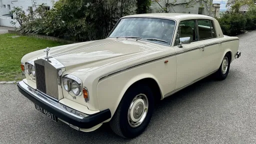 Classic Rolls-Royce Silver Shadow Mk2 in Old English White parked on a driveway, front three-quarter view showing chrome grille and round headlights.