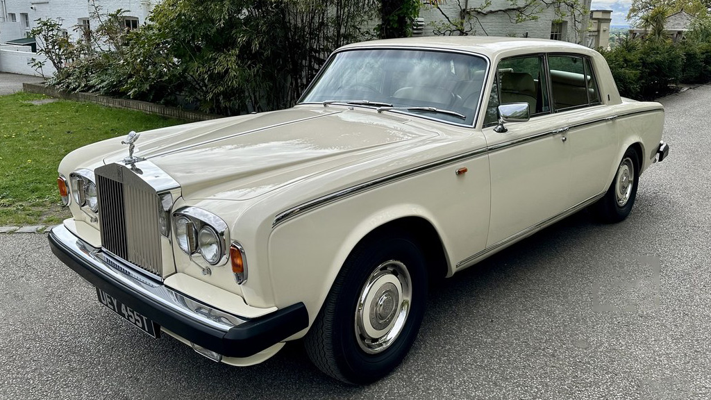 Classic Rolls-Royce Silver Shadow Mk2 in Old English White parked on a driveway, front three-quarter view showing chrome grille and round headlights.