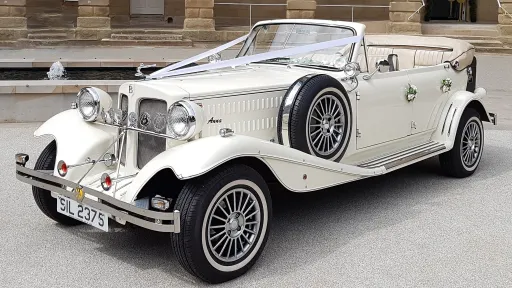 Cream 4 door Beauford convertible wedding car with roof down, parked outside a venue in Warrington.
