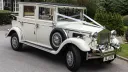 Cream 1930s style Imperial wedding car with chrome headlights and side-mounted spare wheel, parked on a driveway in Cheshire.