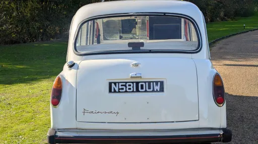 Rear view of classic Fairway taxi cab in Old English White, showing chrome bumper and traditional styling.