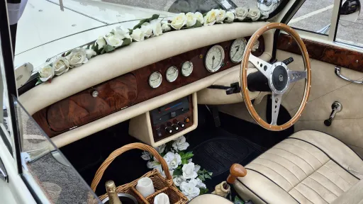 Front interior view of Beauford showing wood dashboard, steering wheel and wedding ribbon decoration.