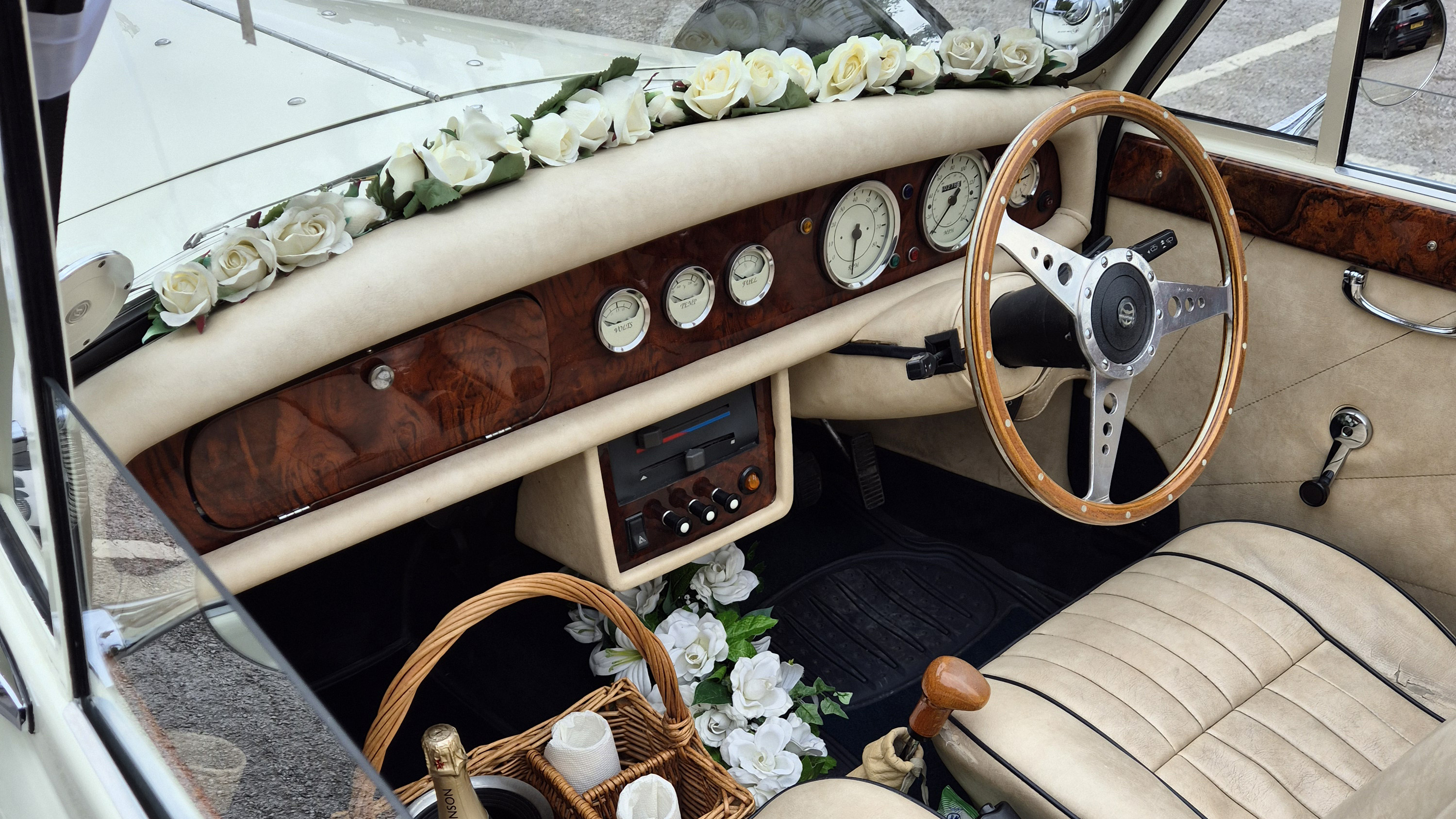 Front interior view of Beauford showing wood dashboard, steering wheel and wedding ribbon decoration.